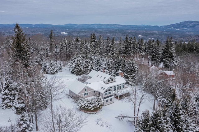 snowy aerial view with a forest view and a mountain view