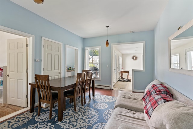 dining space featuring a baseboard heating unit and dark hardwood / wood-style flooring