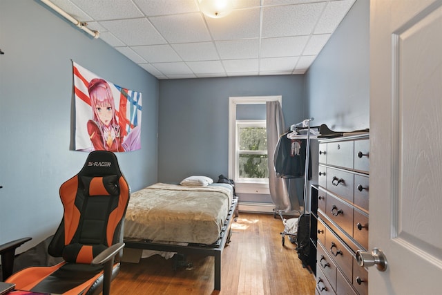 bedroom featuring light hardwood / wood-style flooring and a drop ceiling