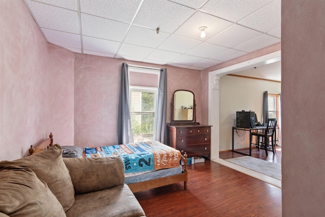 bedroom with a drop ceiling and hardwood / wood-style flooring