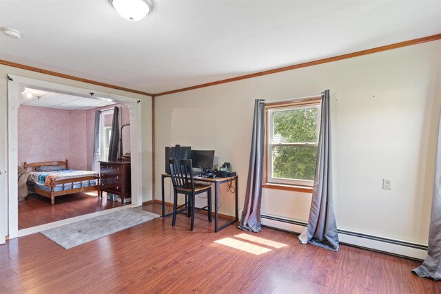 office space featuring crown molding, wood-type flooring, and a baseboard heating unit