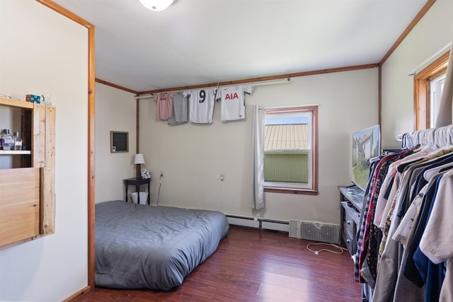 bedroom with a baseboard heating unit, ornamental molding, and dark wood-type flooring