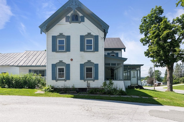 view of front facade with a front lawn and a sunroom