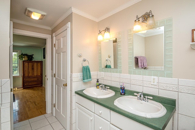 bathroom with tile patterned flooring, vanity, crown molding, and tile walls