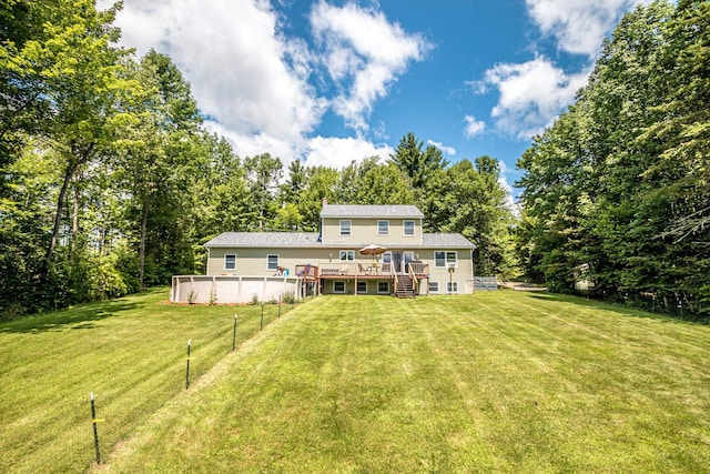 rear view of property featuring a swimming pool side deck and a yard