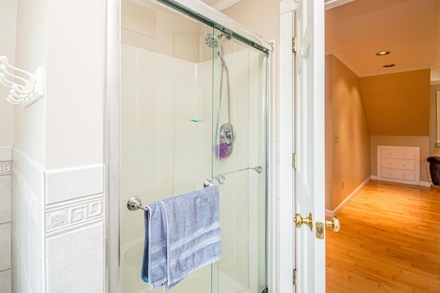 bathroom featuring hardwood / wood-style flooring, vaulted ceiling, and walk in shower