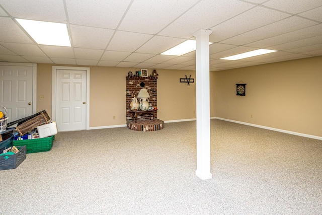 basement featuring a paneled ceiling and carpet