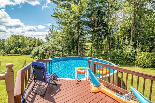 view of pool with a lawn and a deck