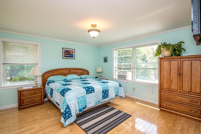 bedroom featuring crown molding, light hardwood / wood-style floors, and cooling unit