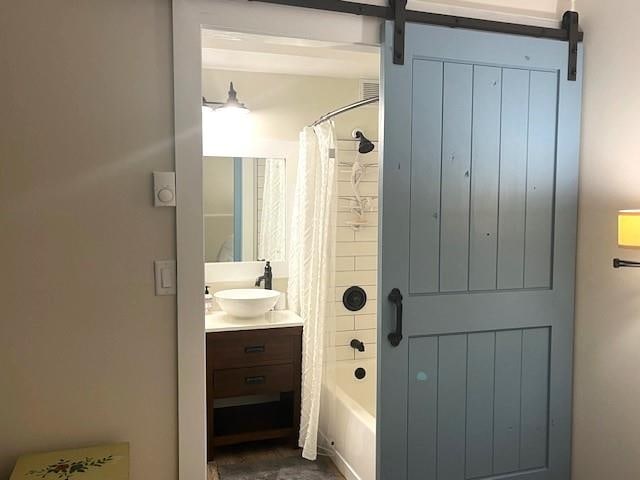 bathroom featuring vanity and shower / bathtub combination with curtain