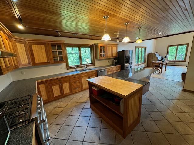 kitchen featuring a center island, appliances with stainless steel finishes, a sink, and tile patterned floors