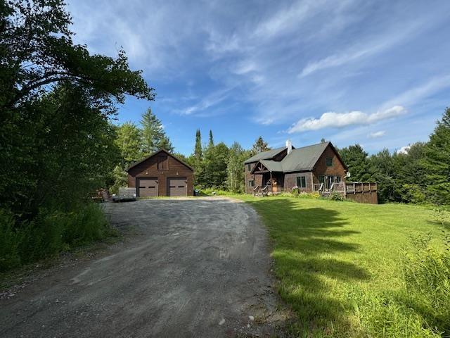 view of front of house featuring a garage, an outbuilding, and a front yard