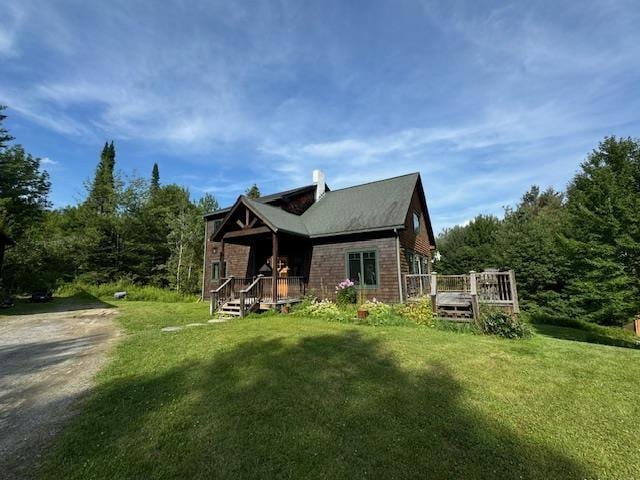 view of front of property with a front yard and a wooden deck