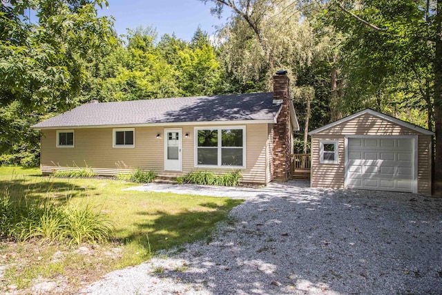 ranch-style house with an outbuilding, a garage, and a front lawn