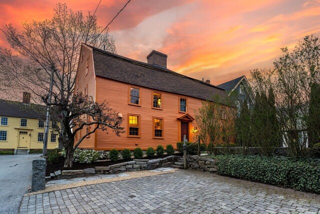 colonial-style house featuring a patio and a fire pit