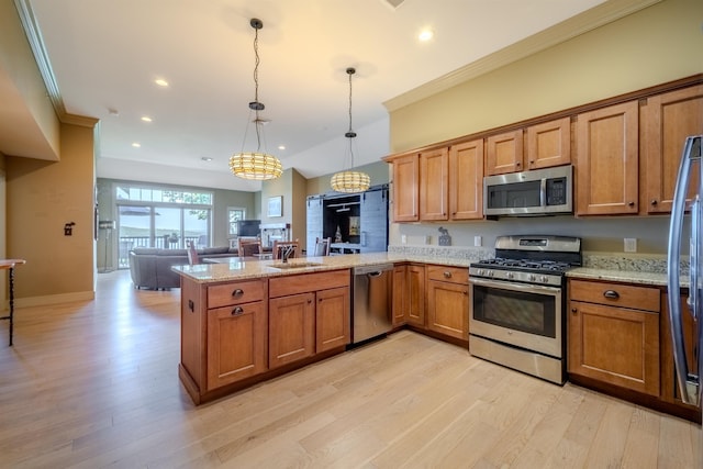 kitchen with a peninsula, light wood-style floors, appliances with stainless steel finishes, brown cabinets, and crown molding