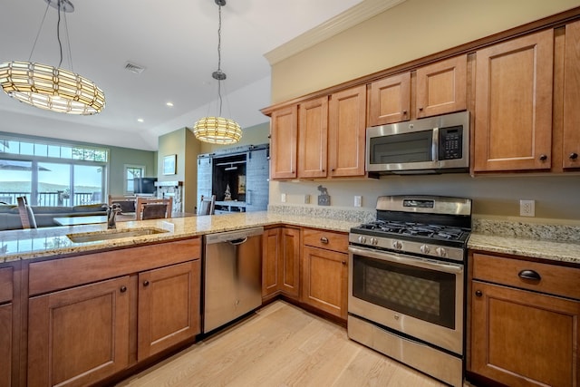 kitchen featuring stainless steel appliances, brown cabinetry, visible vents, and a sink