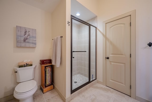 full bath featuring a stall shower, baseboards, toilet, and tile patterned floors