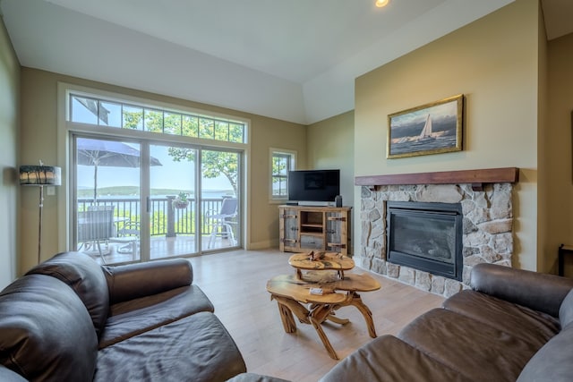 living room with a fireplace, baseboards, and wood finished floors