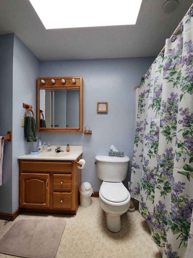 bathroom with toilet, a textured ceiling, and vanity