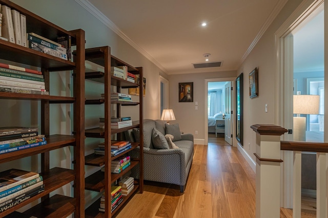 sitting room with visible vents, crown molding, baseboards, and light wood-type flooring