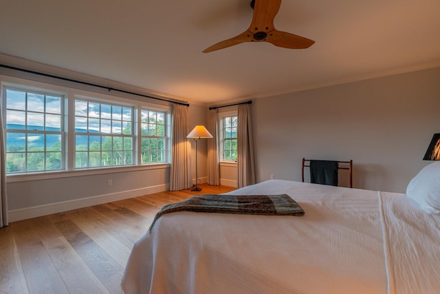 bedroom with baseboards, ornamental molding, wood finished floors, and ceiling fan