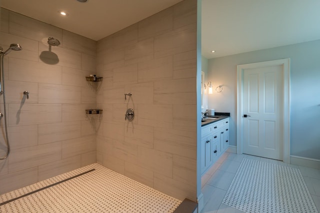 full bathroom featuring tile patterned floors, vanity, baseboards, and tiled shower