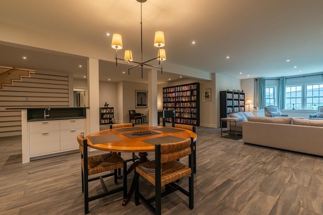 dining space featuring baseboards, wood finished floors, stairway, recessed lighting, and a notable chandelier