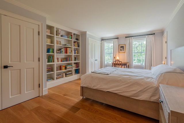 bedroom with crown molding and light wood-style flooring
