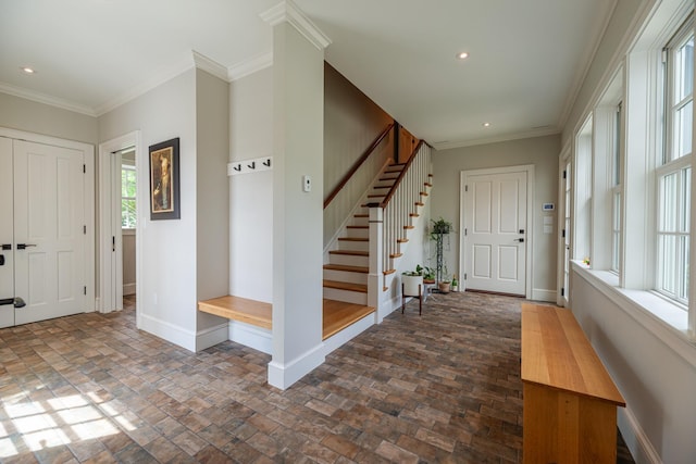 entrance foyer featuring baseboards, stairs, and crown molding