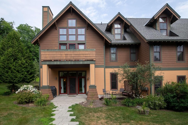 view of front of home with a balcony, a front yard, and a patio area