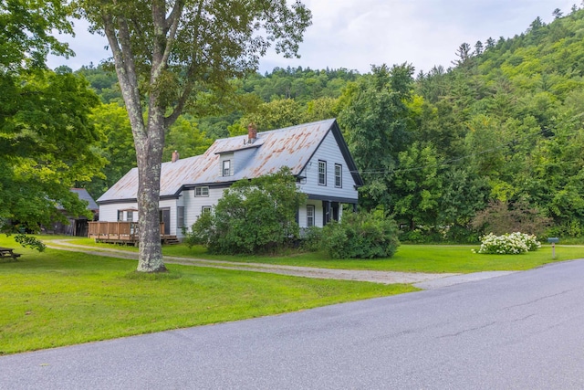 view of property exterior with a wooden deck and a yard