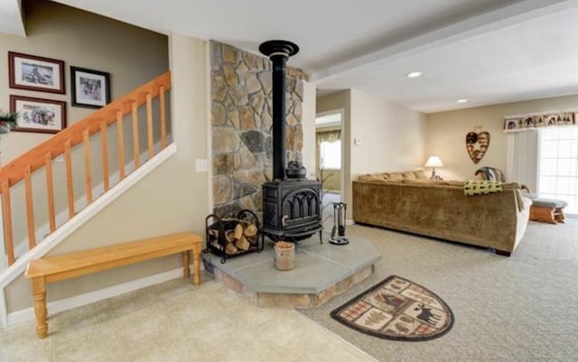 living room with recessed lighting, baseboards, stairway, beamed ceiling, and a wood stove