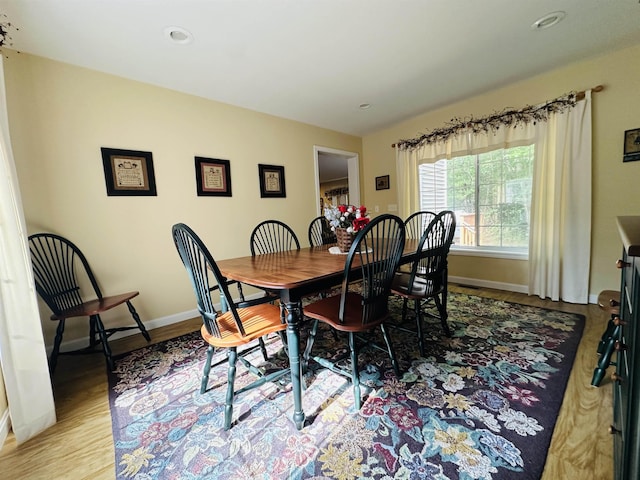 dining space with light wood-style flooring and baseboards