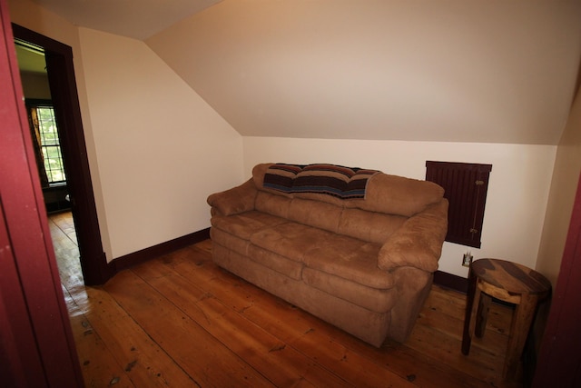 living area with lofted ceiling, wood-type flooring, and baseboards
