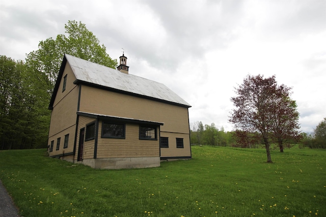 view of home's exterior featuring a chimney and a lawn