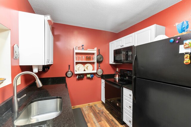 kitchen with sink, light hardwood / wood-style flooring, black appliances, a textured ceiling, and white cabinets