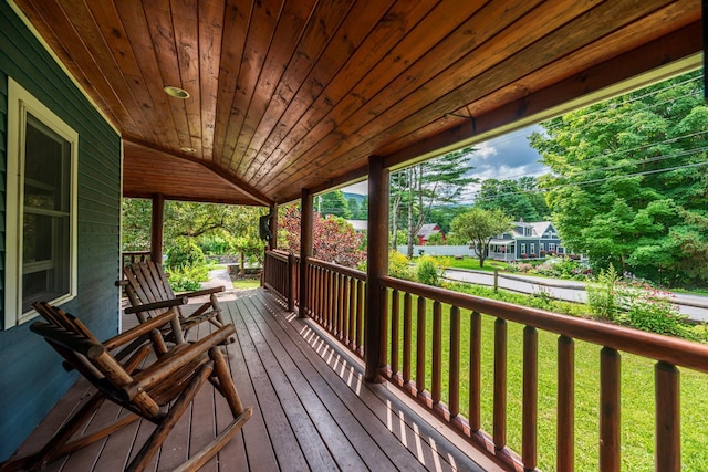 deck with covered porch and a lawn