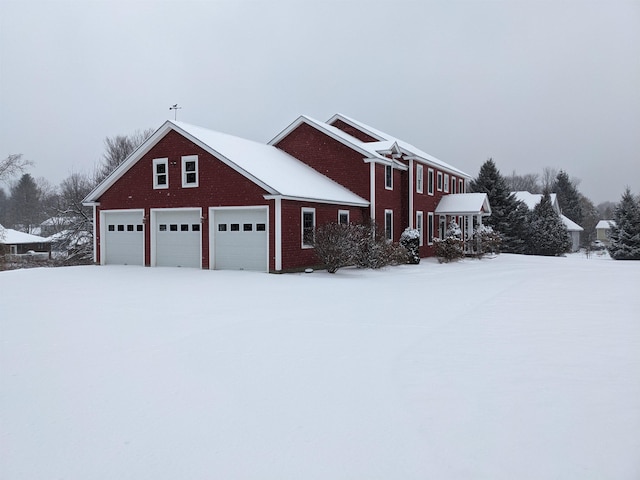 view of snowy exterior with a garage