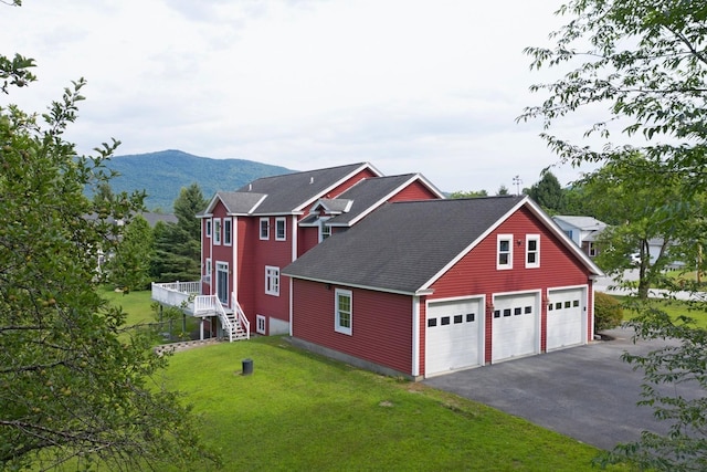 exterior space with a mountain view, a garage, and a front yard