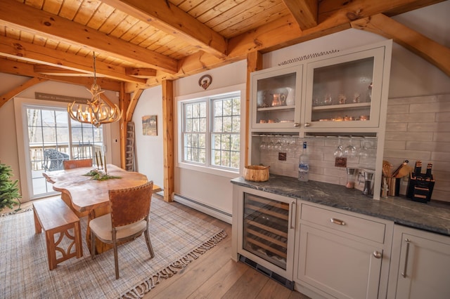 interior space featuring dark stone countertops, a baseboard heating unit, white cabinets, decorative light fixtures, and beverage cooler