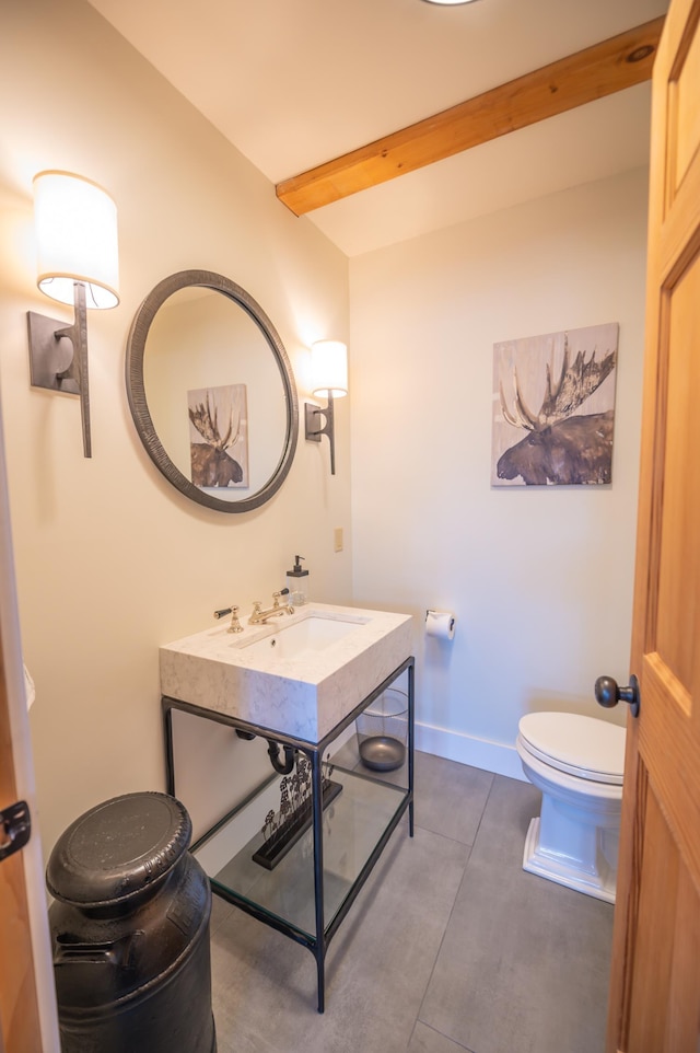 bathroom featuring beamed ceiling, sink, tile patterned floors, and toilet