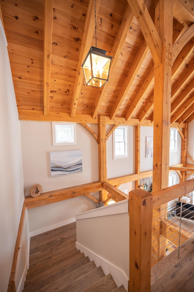 staircase featuring hardwood / wood-style flooring, vaulted ceiling with beams, a chandelier, and wood ceiling