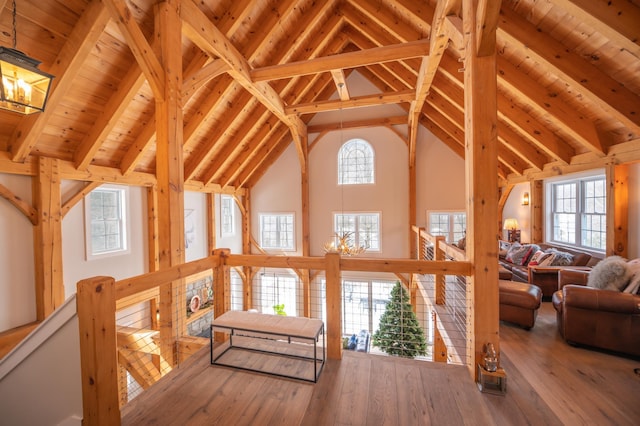 interior space with wood-type flooring, wooden ceiling, a chandelier, and beamed ceiling