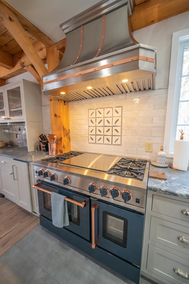 kitchen featuring tasteful backsplash, double oven range, and island range hood