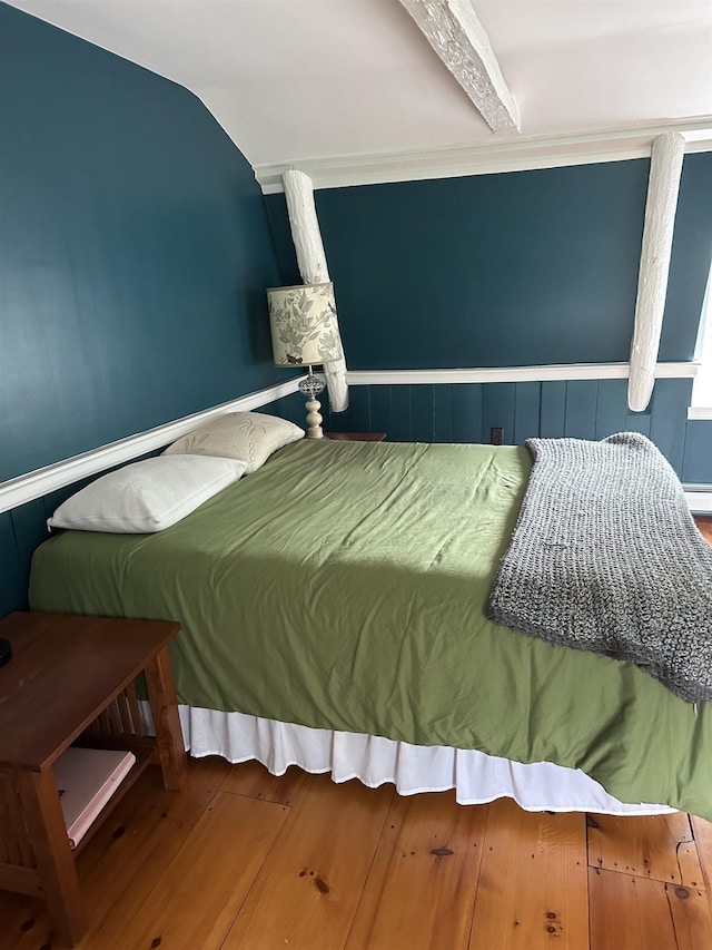 bedroom with wood-type flooring and lofted ceiling with beams