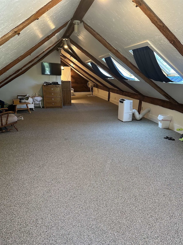 additional living space featuring lofted ceiling with skylight and carpet flooring