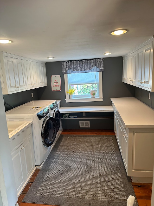 clothes washing area featuring cabinets and washing machine and dryer