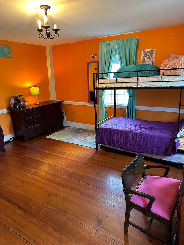 bedroom featuring an inviting chandelier and hardwood / wood-style floors