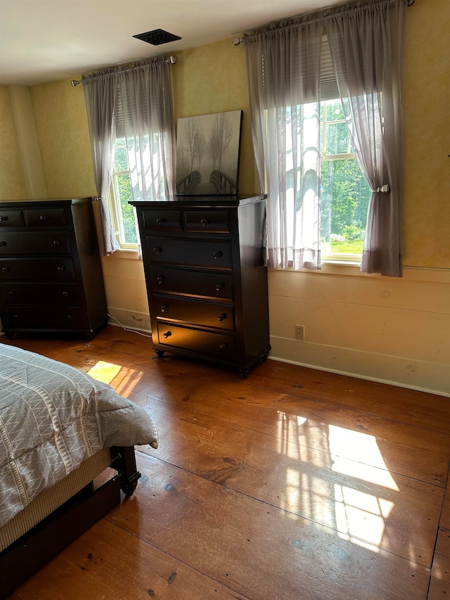 bedroom featuring multiple windows and hardwood / wood-style flooring